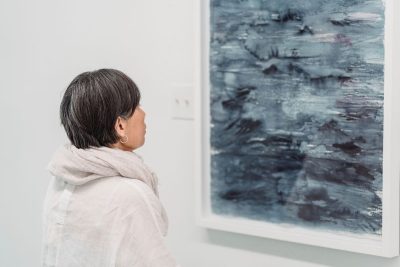 ""art collector looking at blue abstract artwork