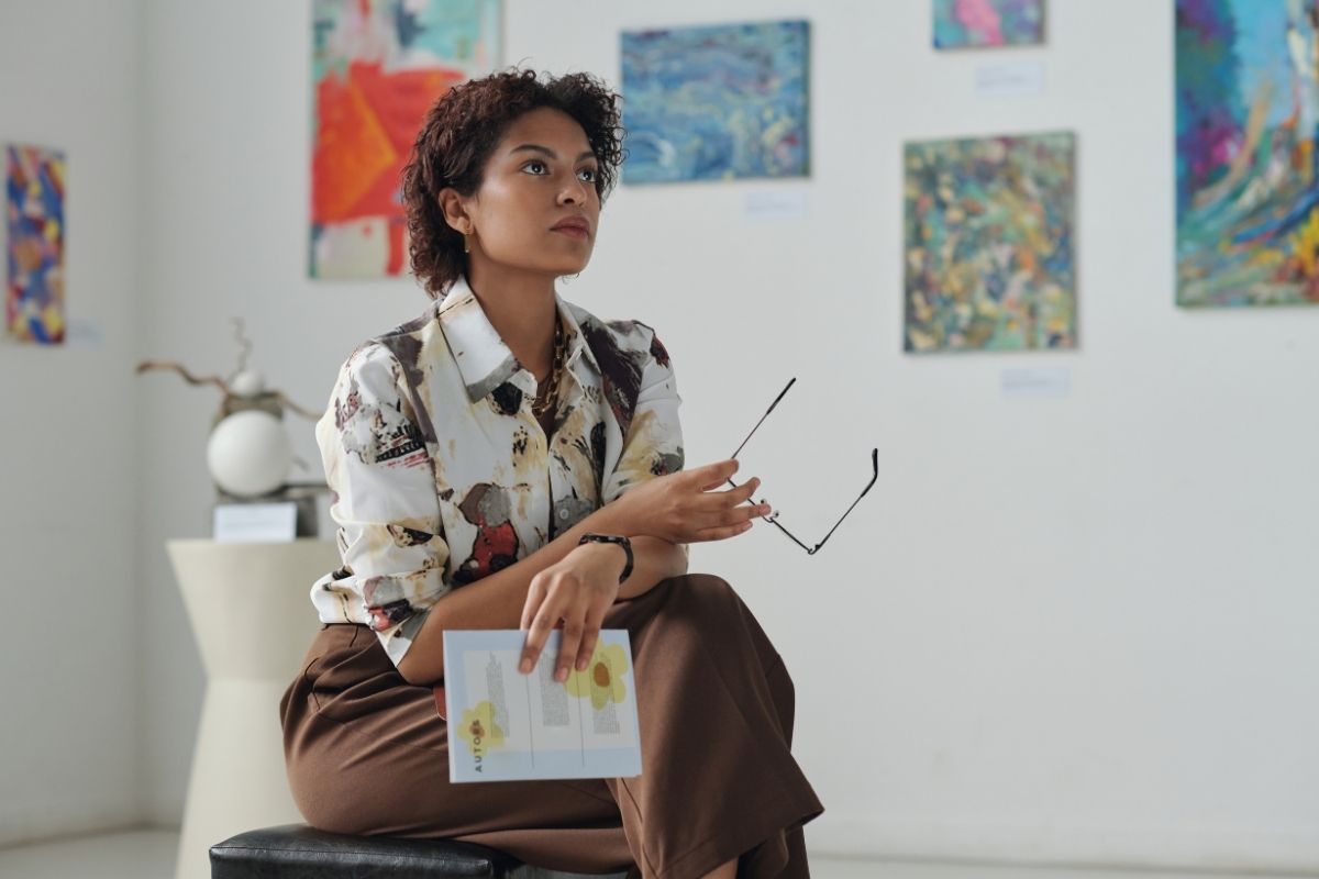 ""woman sitting in art gallery looking at the exhibition