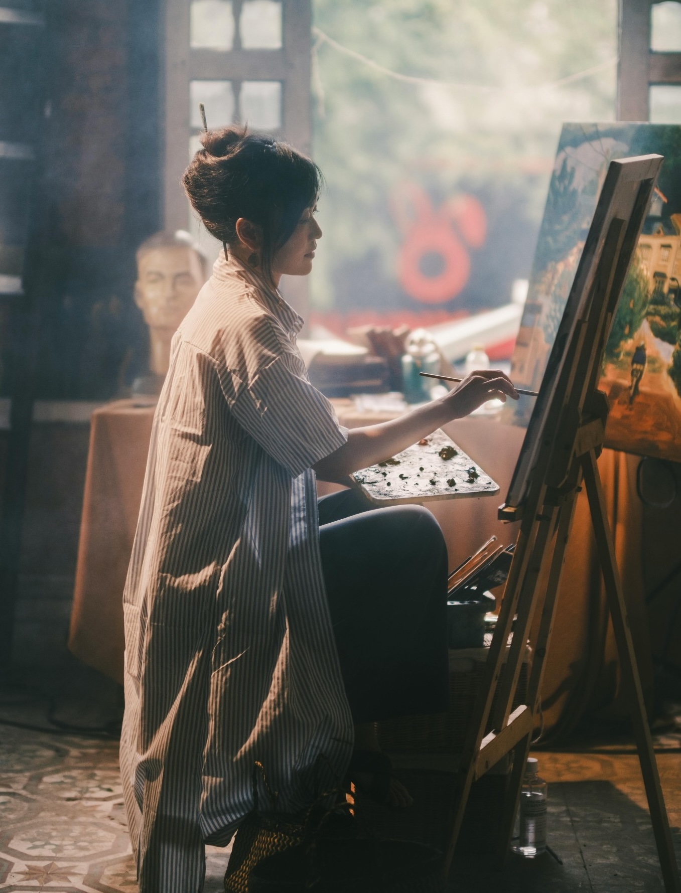 artist painting in her studio at an easel.