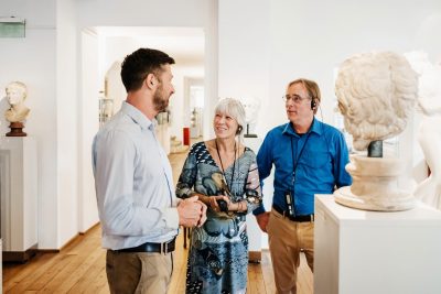 museum tour guide presenting to older couple.