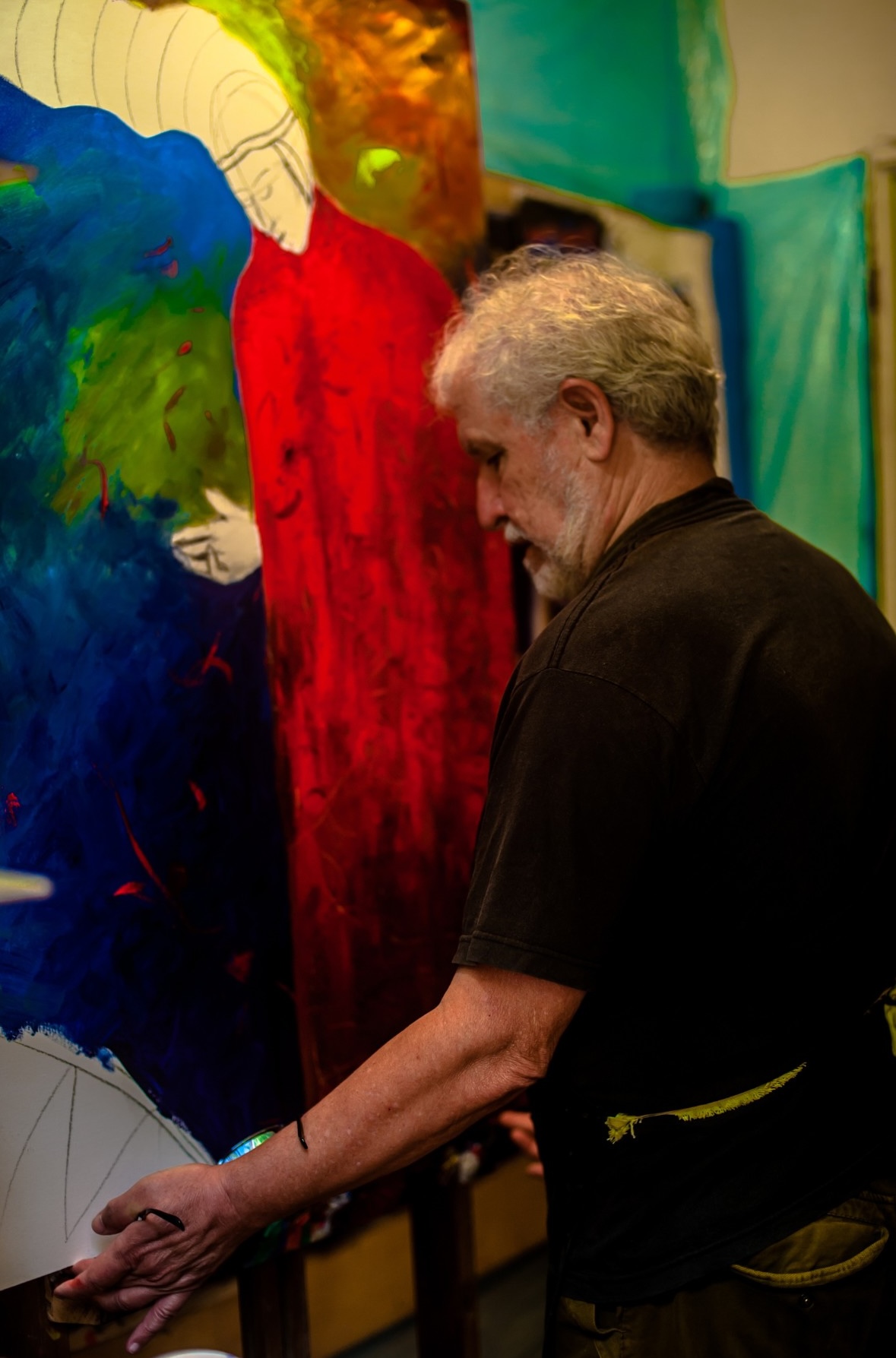 older artist working on a large scale painting and drawing.