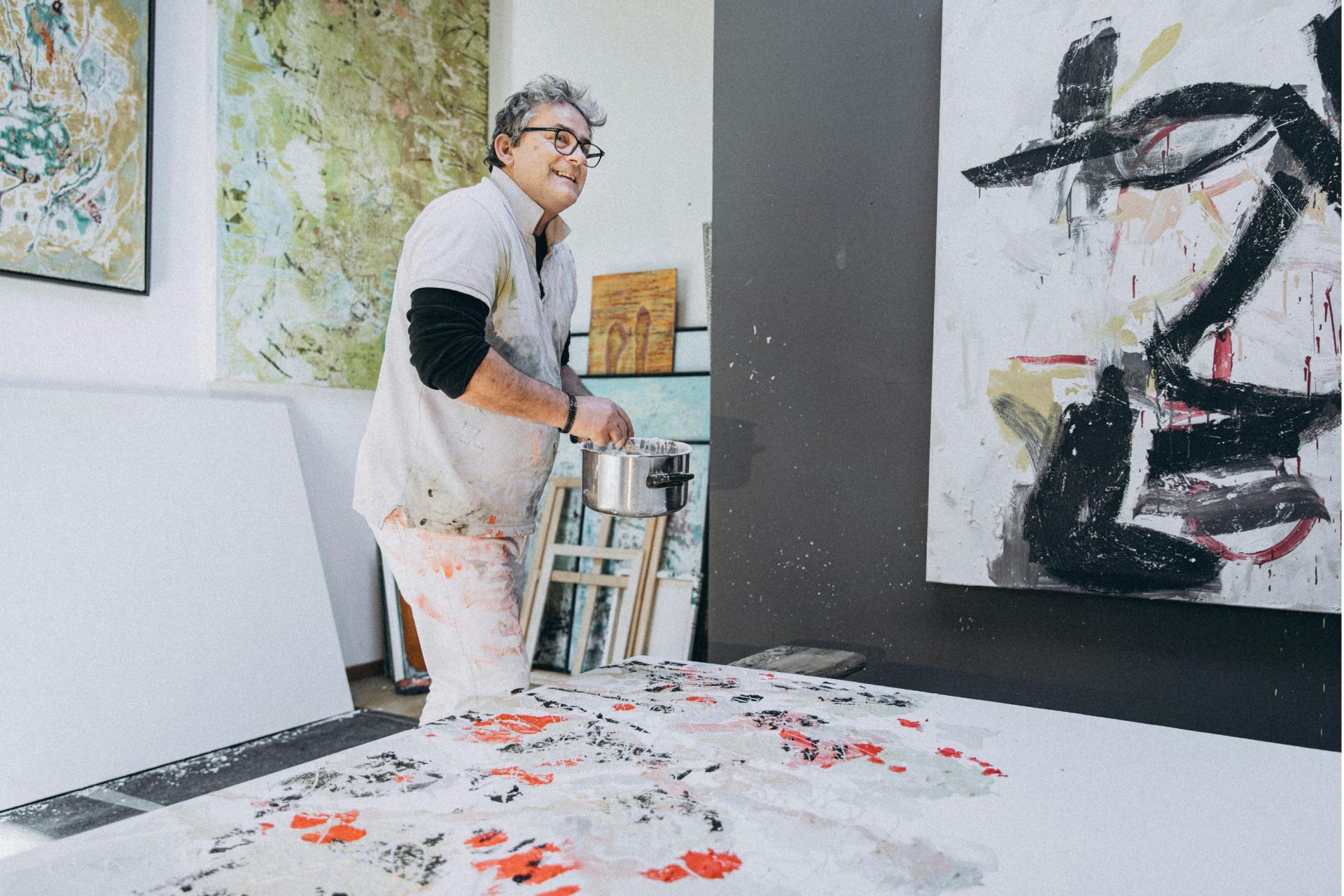 artist creating a splatter painting in their studio.