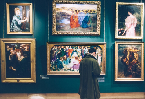 Person with artwork on display in a museum