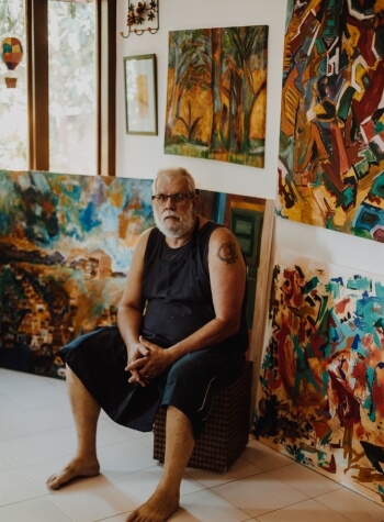 Artist sitting in front of his artwork