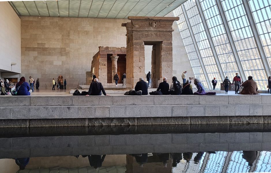 Dimitry Vesensky among museum visitors resting beside a historic temple exhibit.