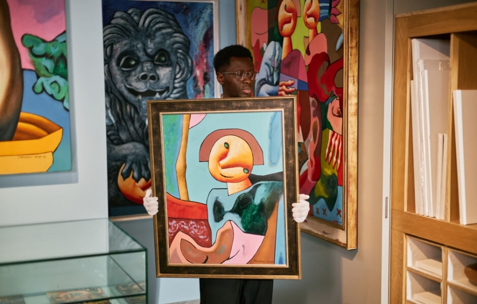 Gallery worker moving artwork.