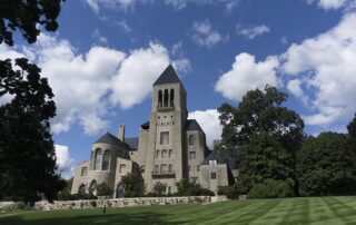 Wide angle photo of castle-like mansion surrounded by trees. 